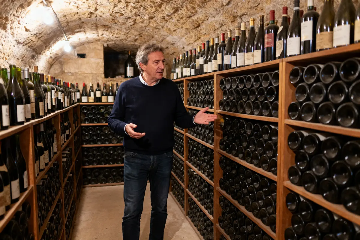 Michel-Jack Chasseuil visite une cave à vin remplie de bouteilles prestigieuses